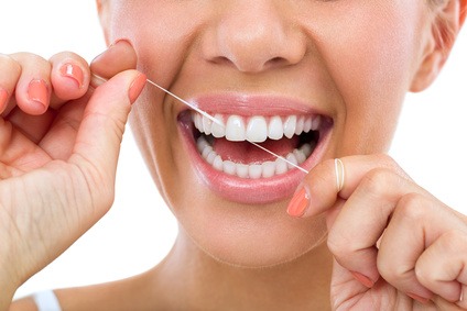 Young woman flossing her teeth , close up , isolated on white background